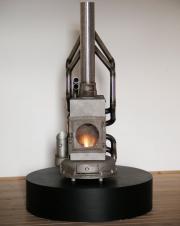 Fa pusztí­tó, 2012, heat&lightbox, működő fatüzelésű vaskályha, elhasznált motorblokkból, 123x36x43cm